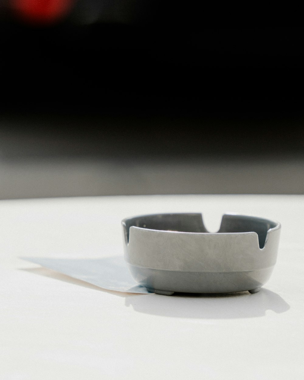 a close up of a white table with a black object in the background