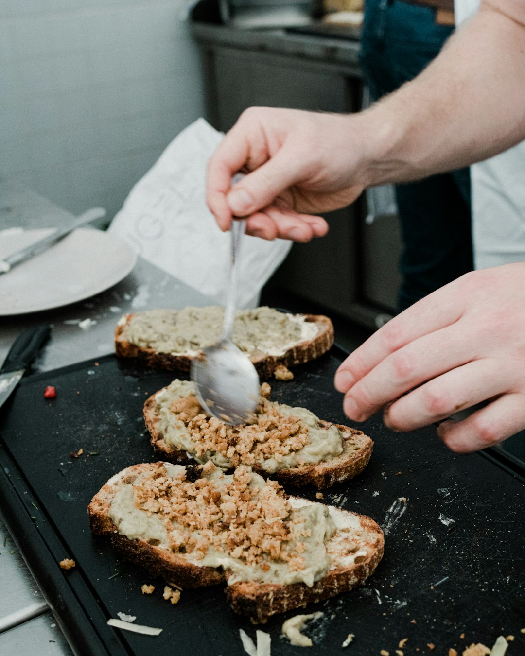 a person cutting bread with a knife on a tray