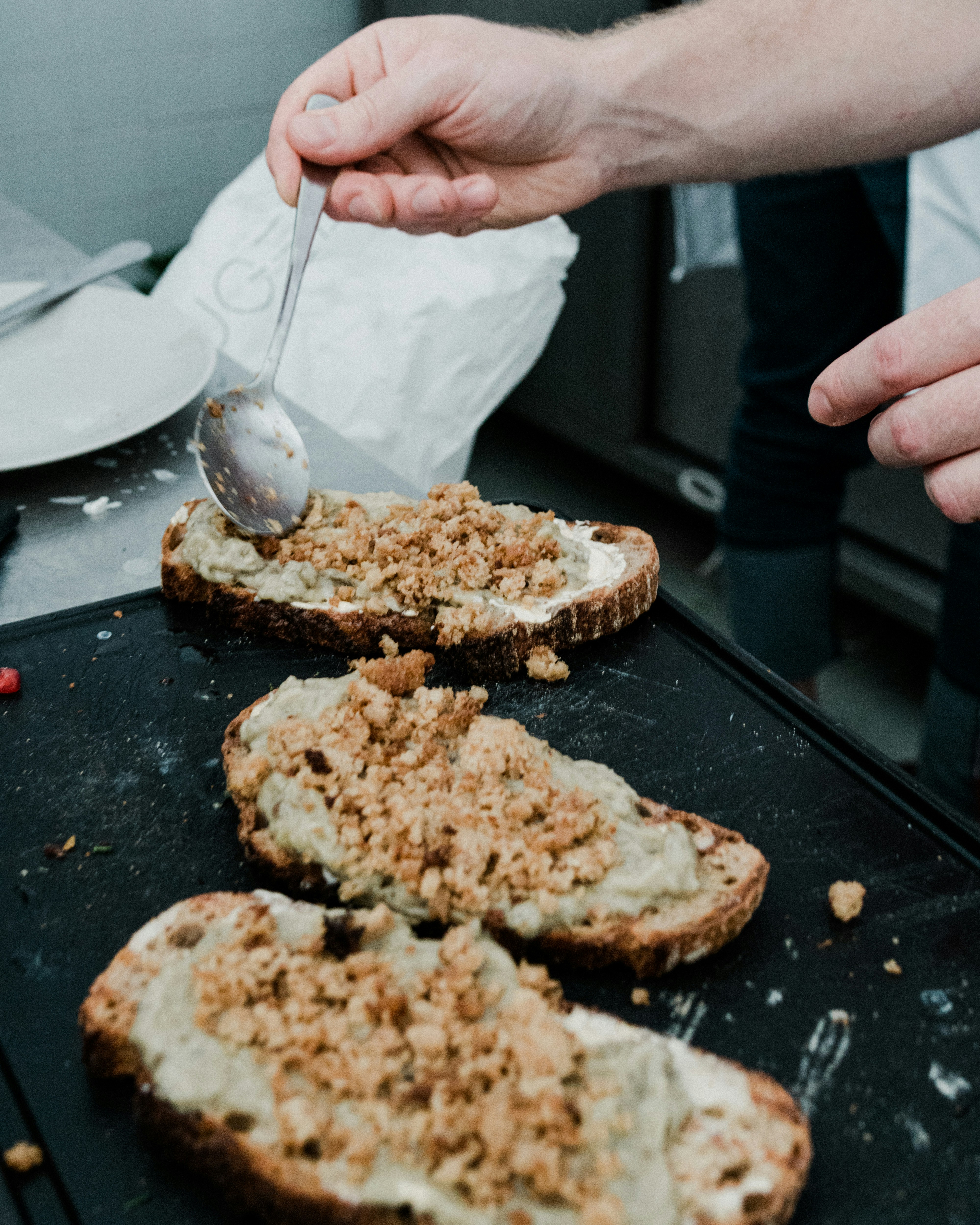 a person spooning something out of a piece of bread