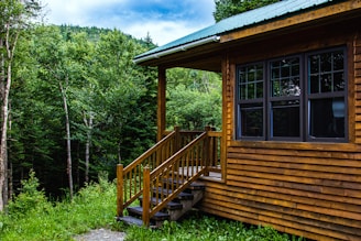 Rainwater collection system installed beside a cozy cabin surrounded by lush forest.