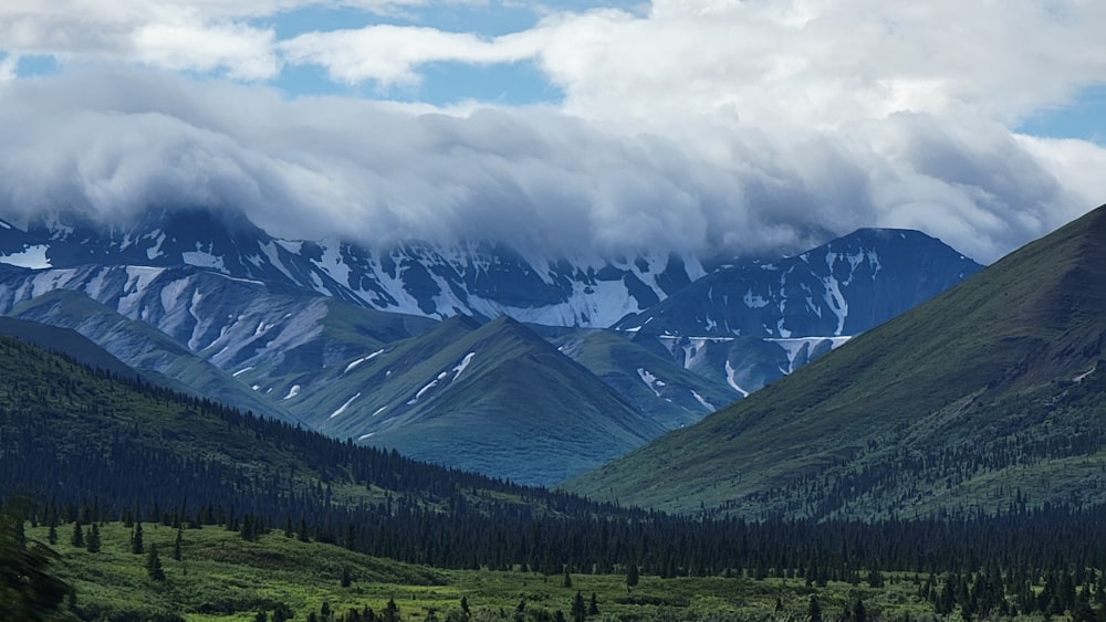 the mountains are covered in snow and clouds