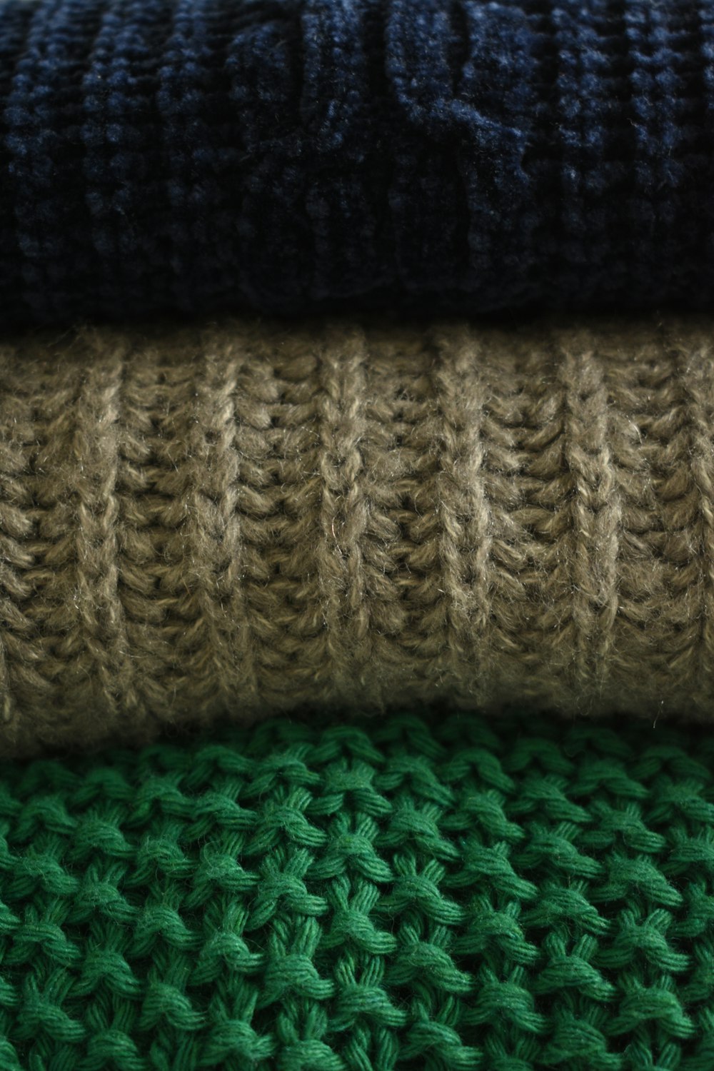a close up of a pile of knitted blankets