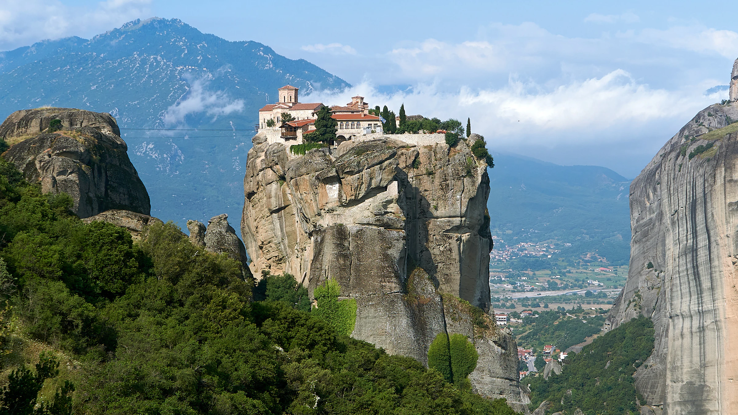 A monastery perched on a towering rock pillar at Meteora, with the valley of Kalambaka below