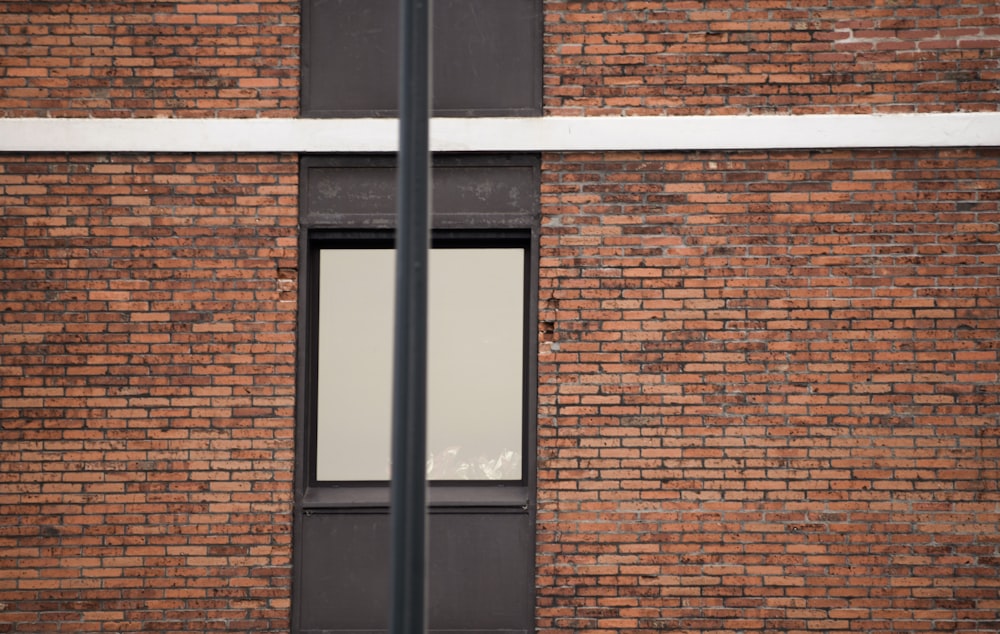 un edificio in mattoni con una finestra e un cartello stradale di fronte ad esso