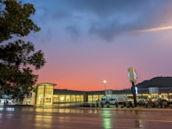 Wide shot of a commercial building with solar panels and smart lighting at dusk.