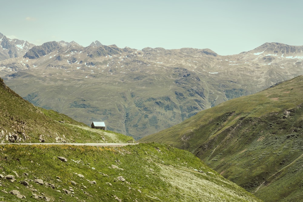 a road going through a valley with mountains in the background