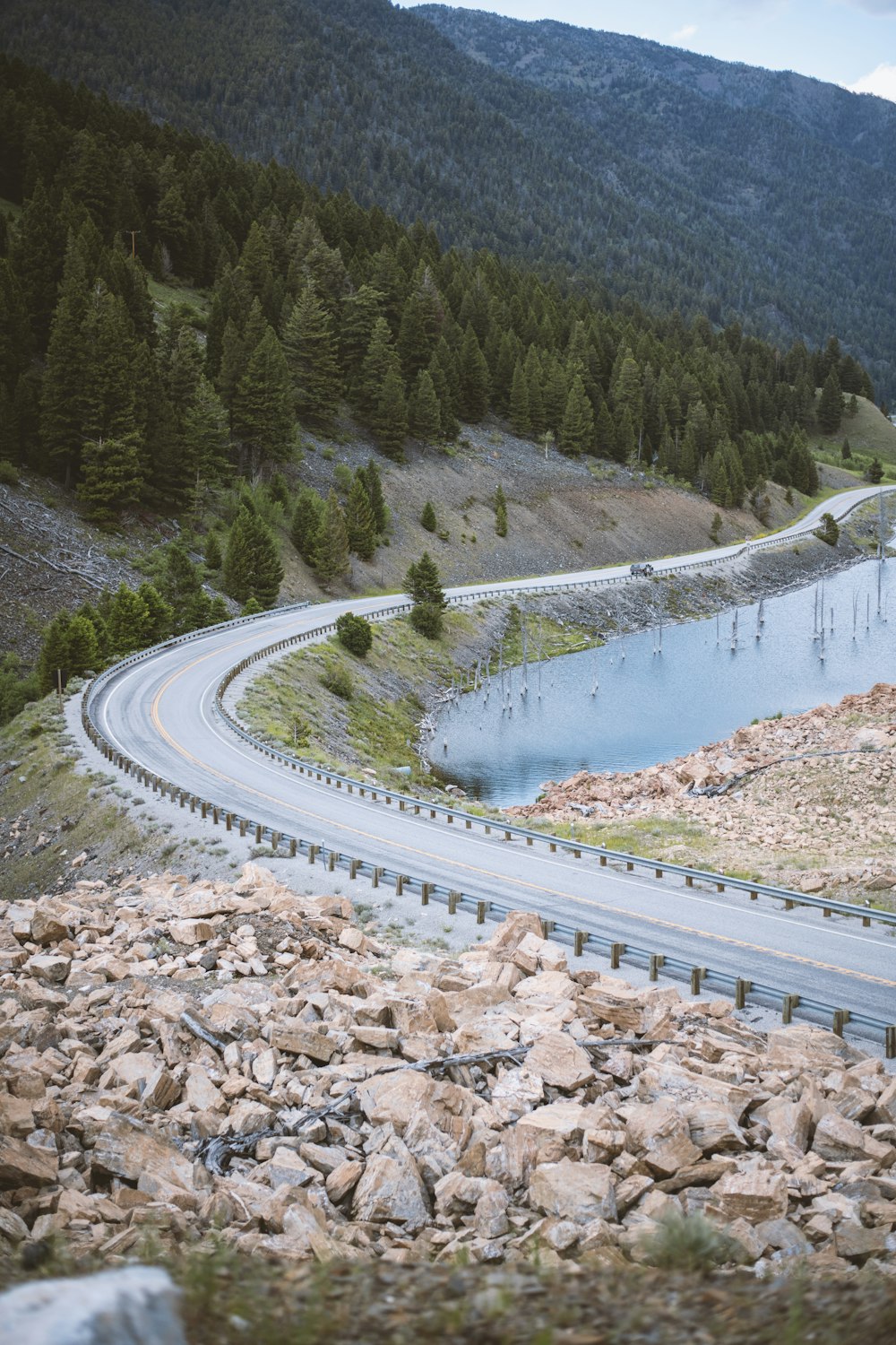 a winding road with a lake in the middle of it