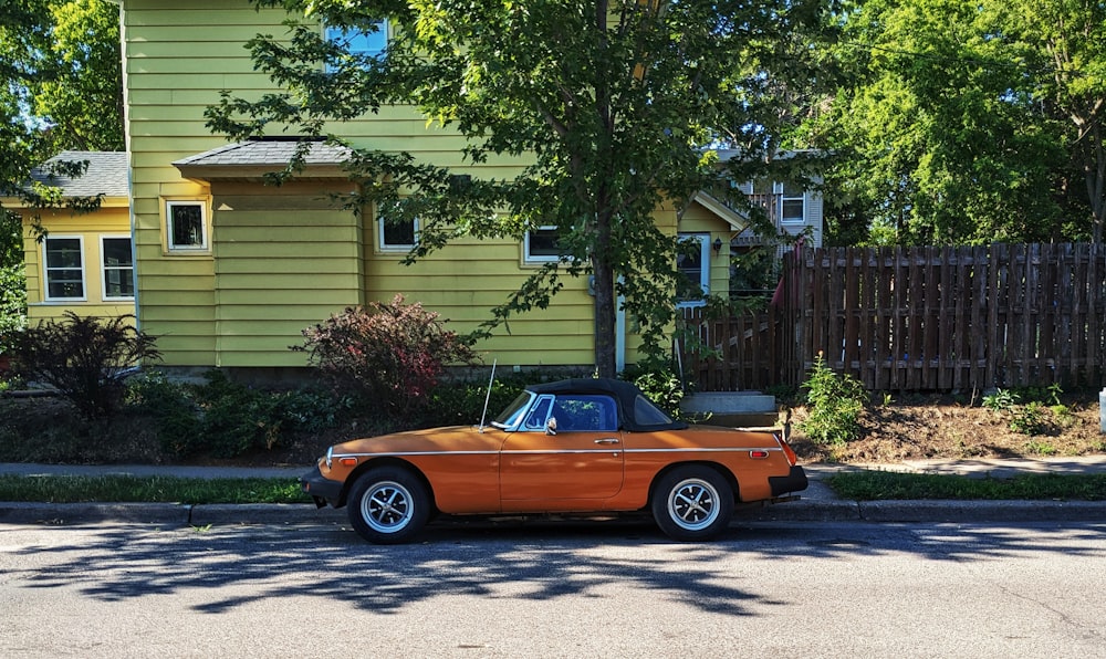 an orange car parked on the side of the road