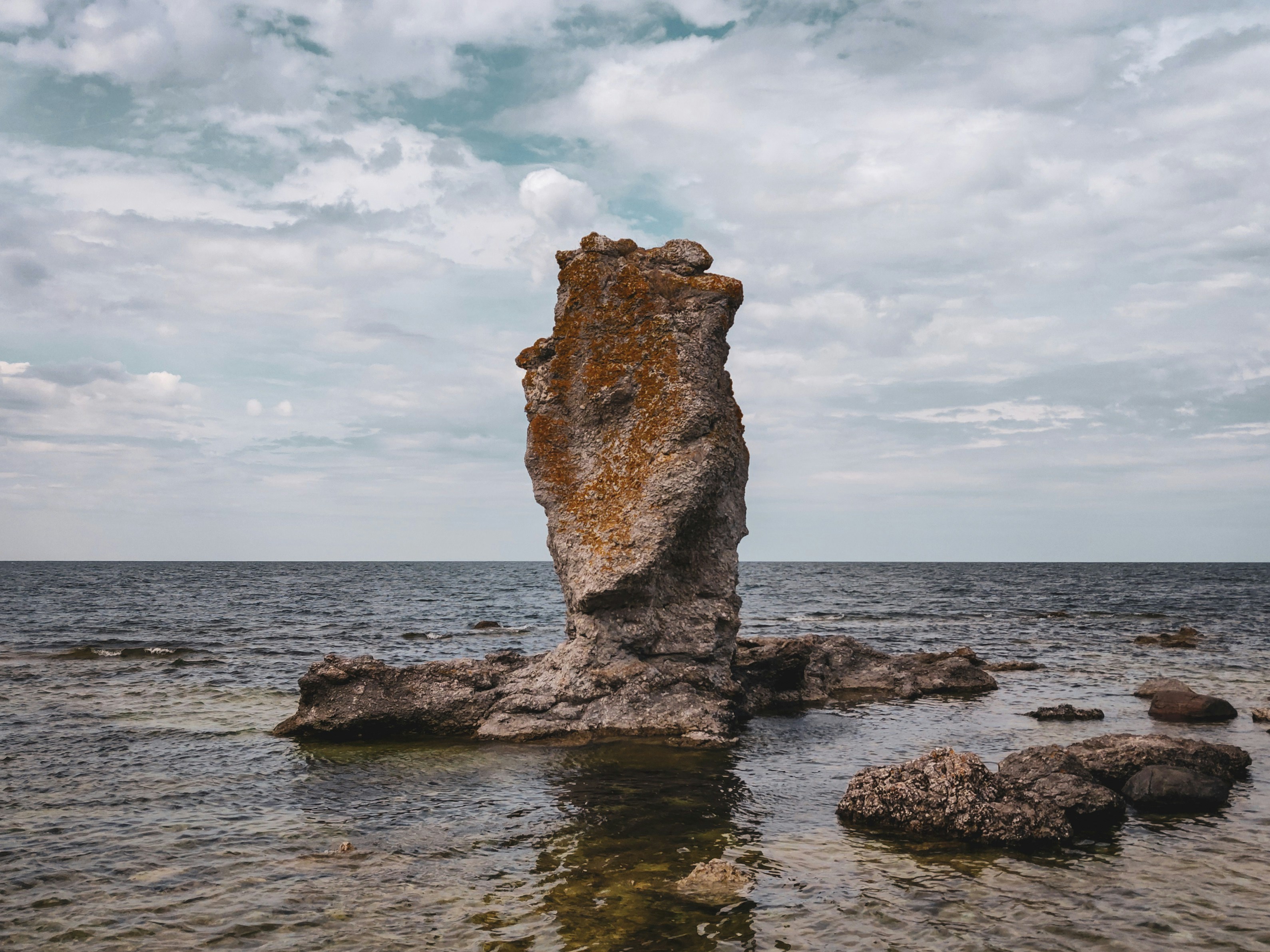 a large rock sticking out of the water