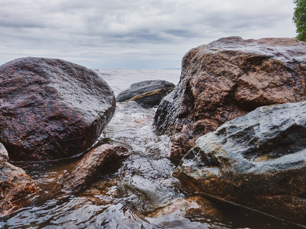 a couple of large rocks sitting on top of a body of water