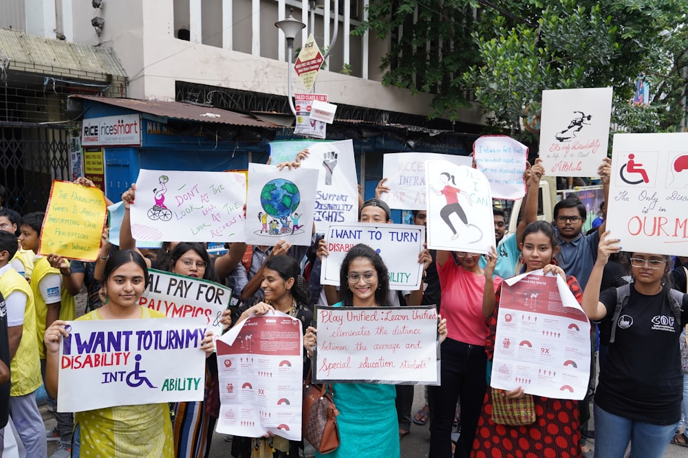 a group of people holding up signs in the street