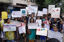 A group of people is gathered holding various signs and posters advocating for disability rights and empowerment. The signs carry messages promoting inclusivity, equal opportunities, and changing perceptions about disabilities. The crowd consists of diverse individuals, including children and adults.
