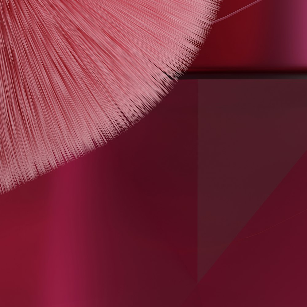 um close up de um pincel rosa em um fundo vermelho