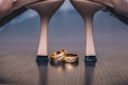 a pair of gold wedding rings sitting on top of a wooden table