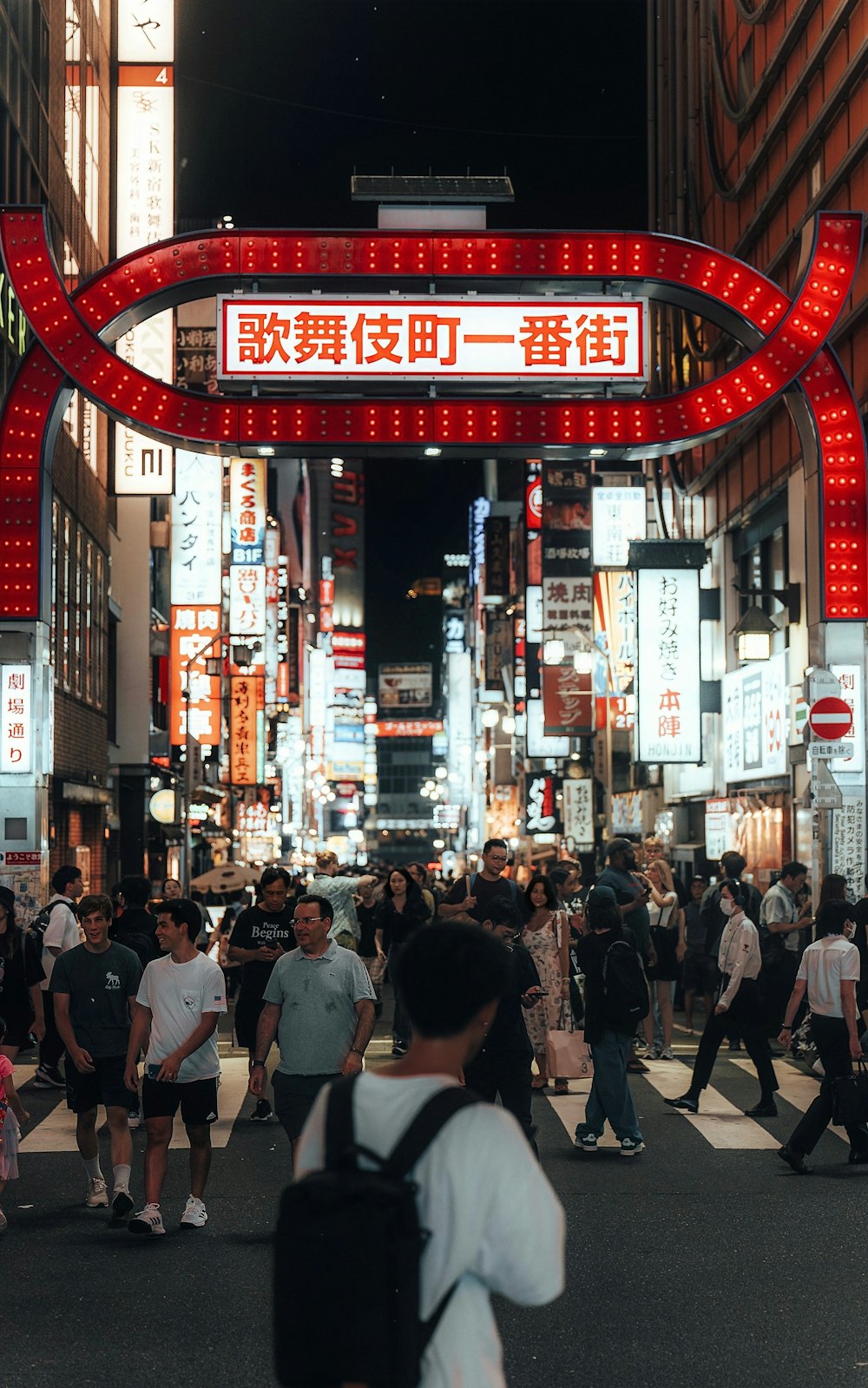 a group of people crossing a street at night