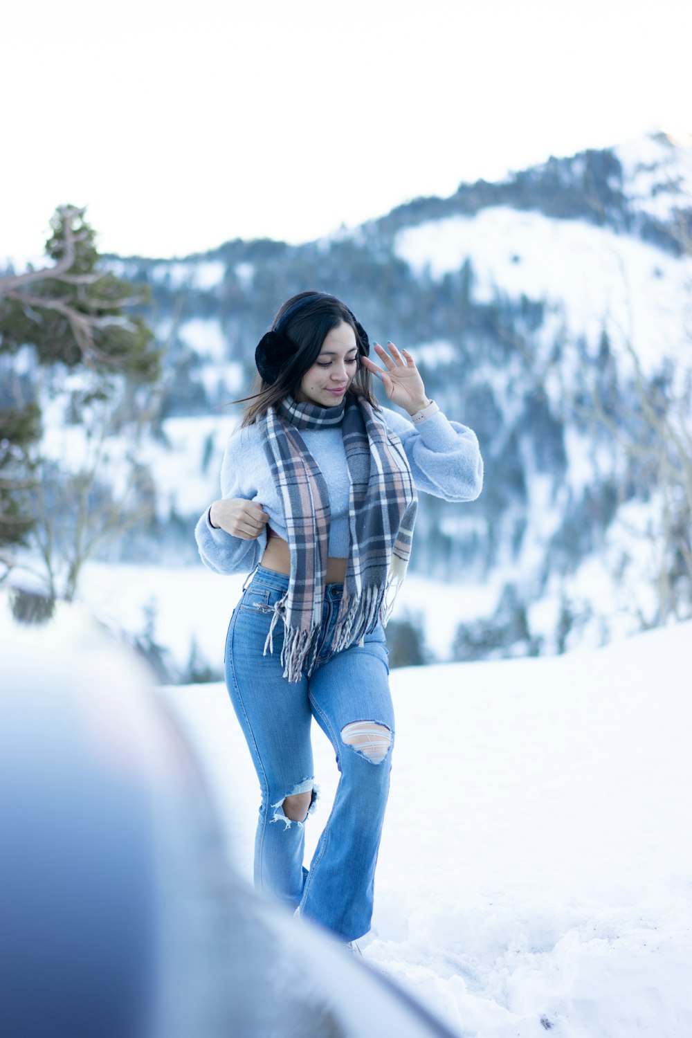 a woman walking in the snow wearing a scarf