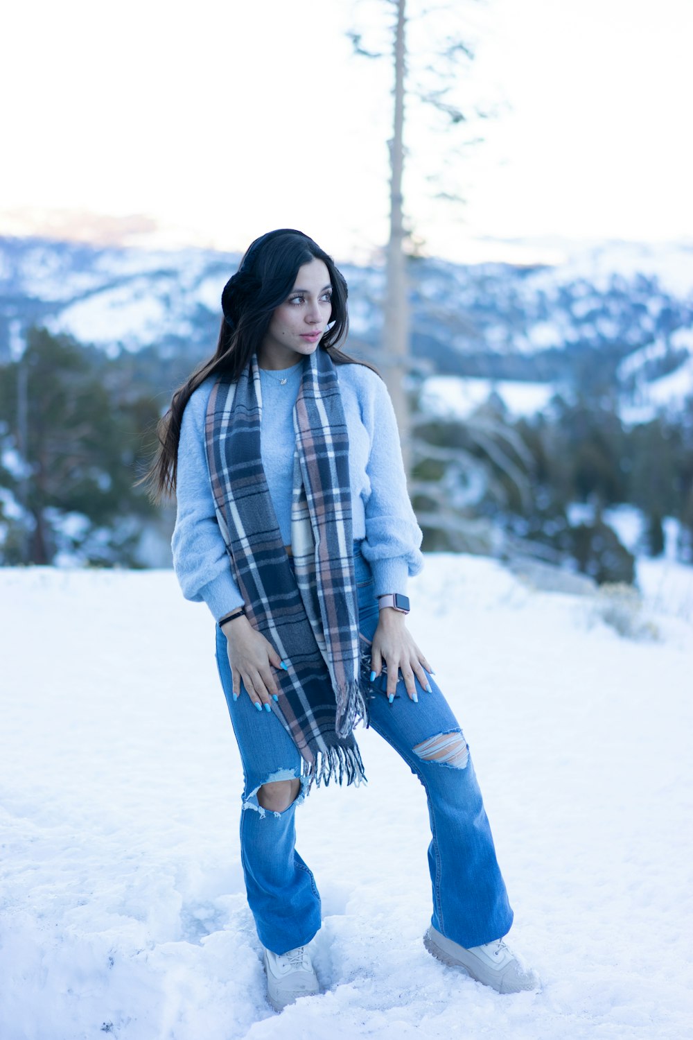 a woman standing in the snow wearing a scarf