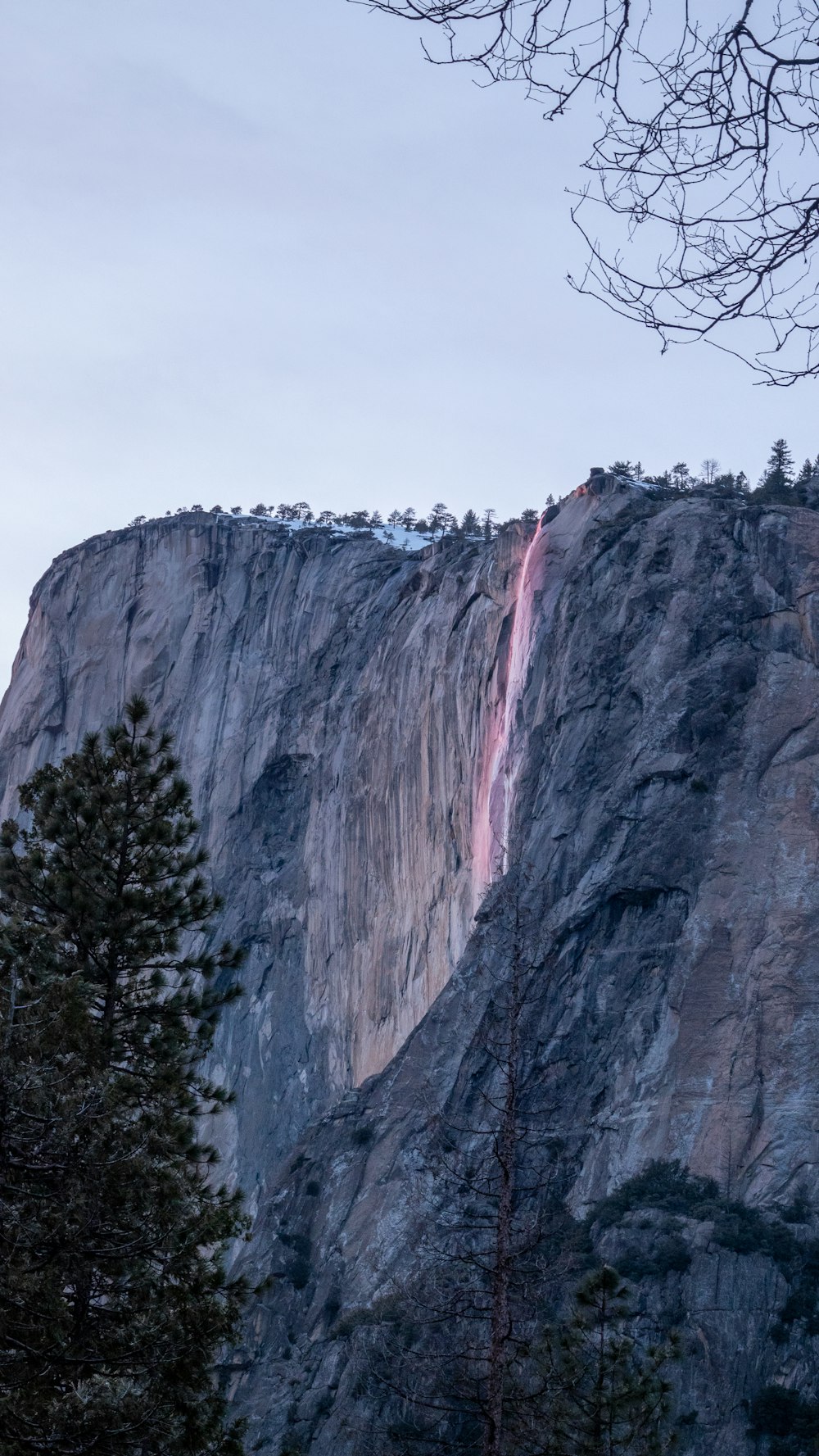 a tall mountain with a waterfall coming out of it's side