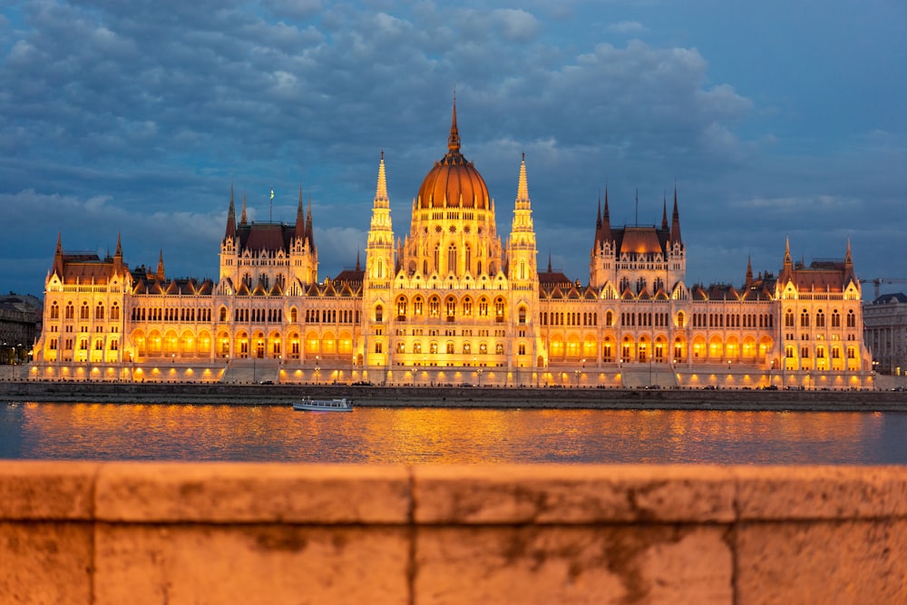 a large building lit up at night next to a body of water