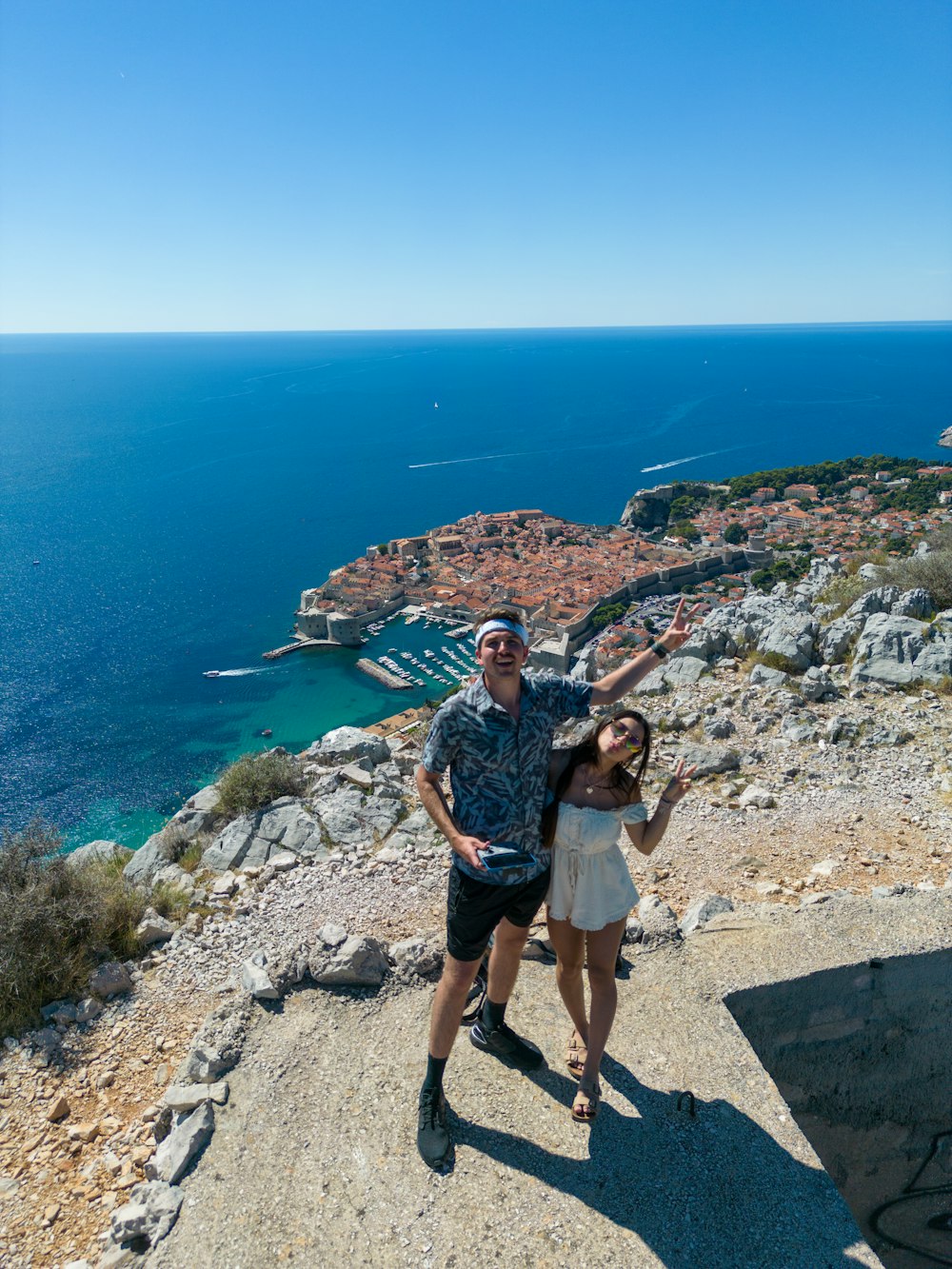 a man and a woman standing on top of a mountain