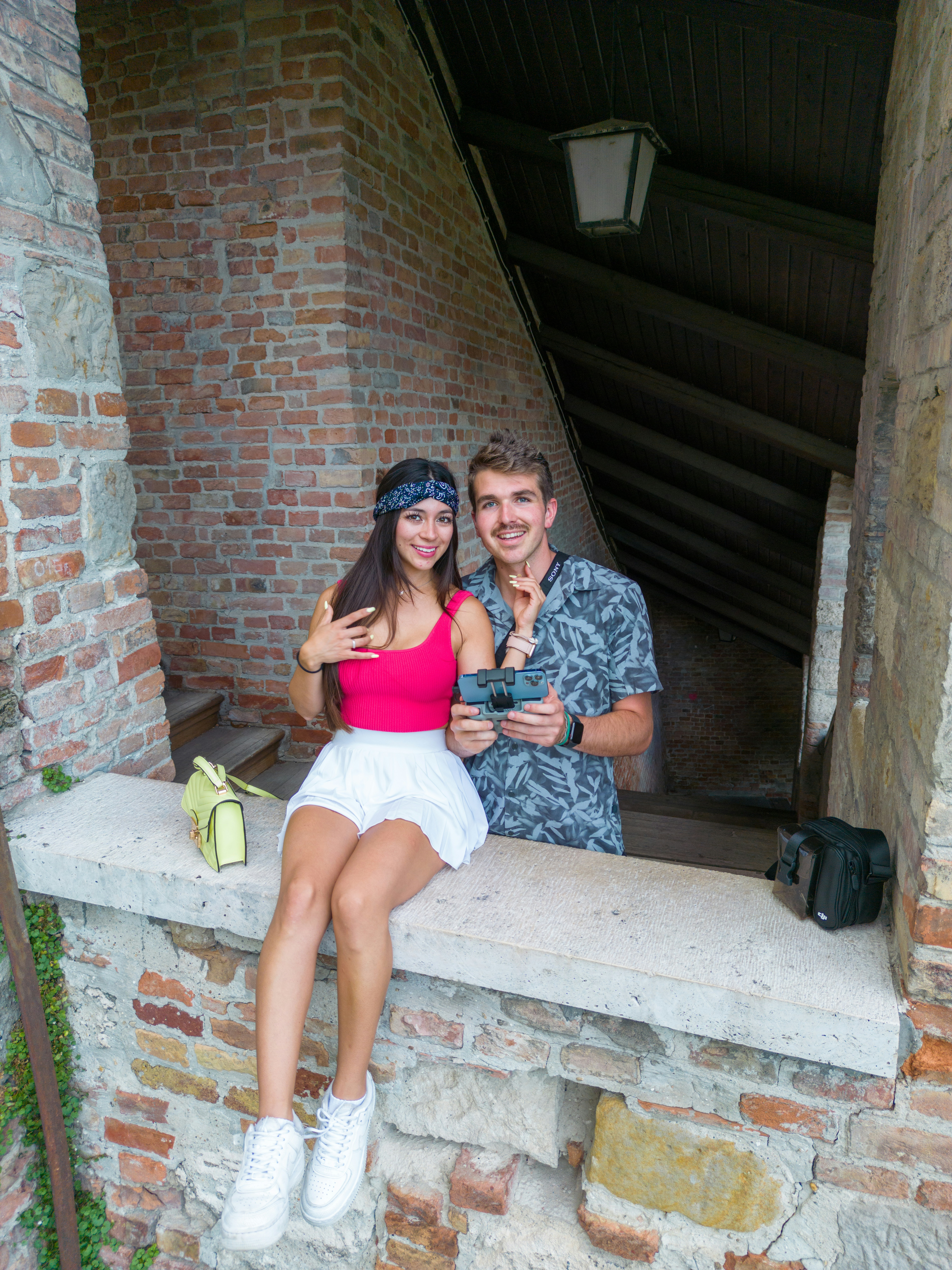 a man and a woman are sitting on a ledge