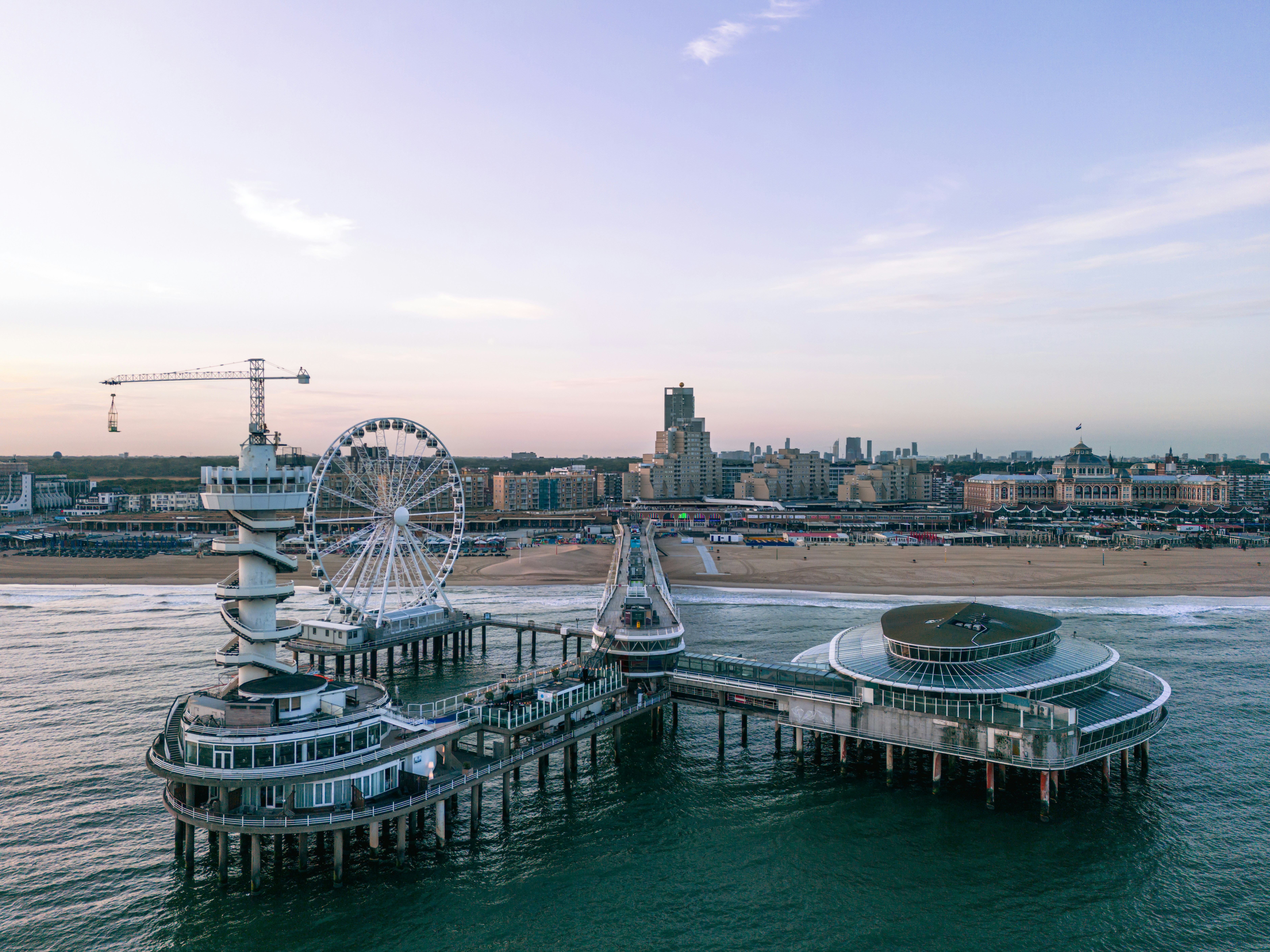 an aerial view of a pier with a ferris wheel in the background