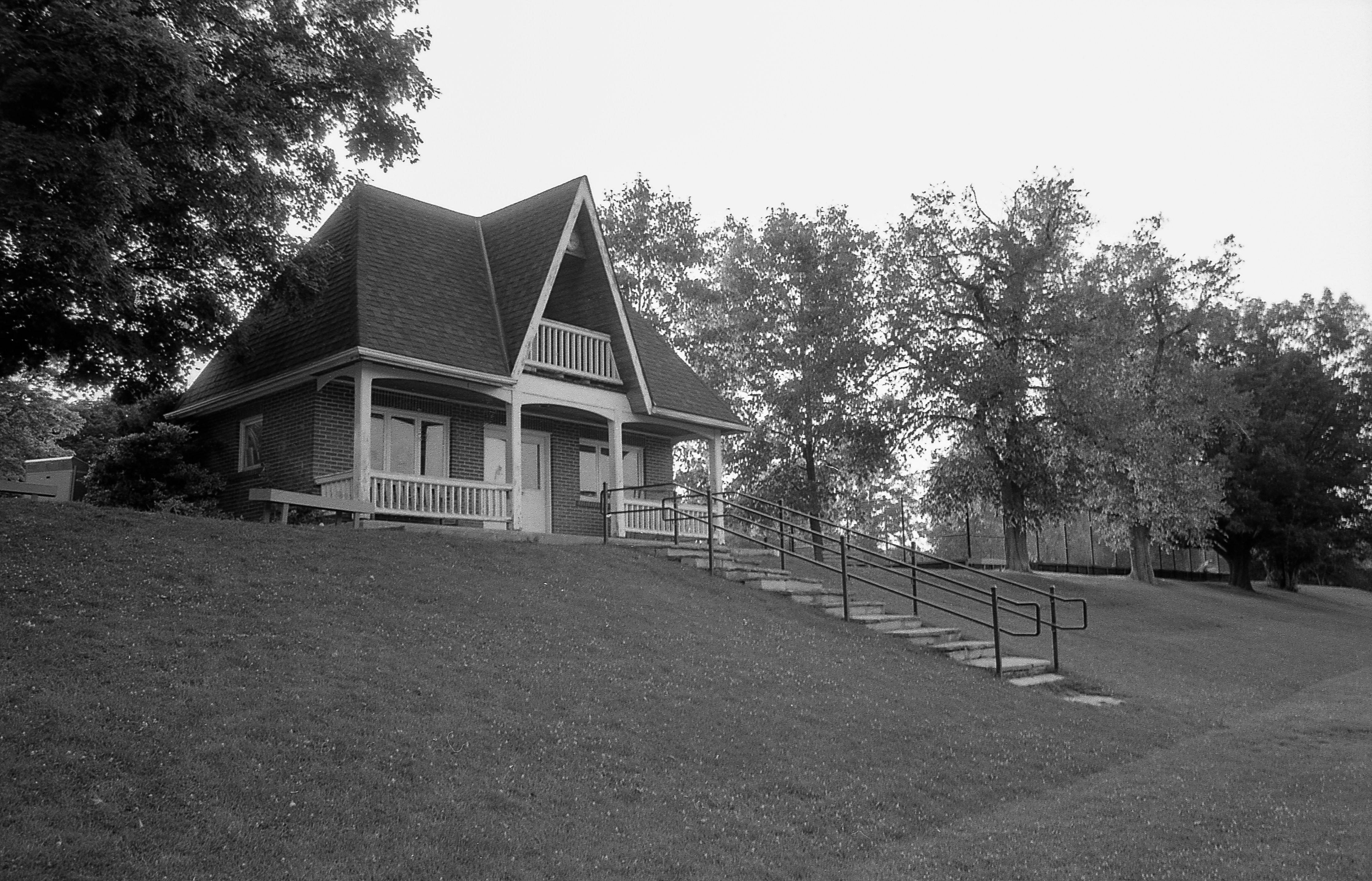 a black and white photo of a house on a hill