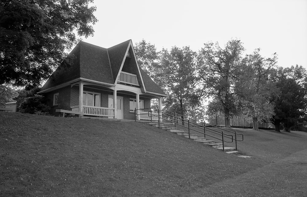 a black and white photo of a house on a hill