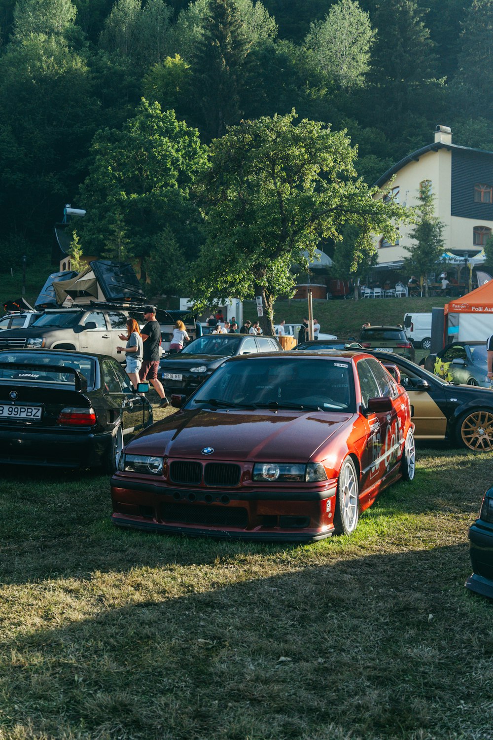 a group of cars parked on top of a grass covered field