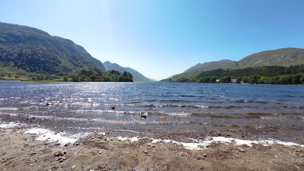 a body of water with mountains in the background