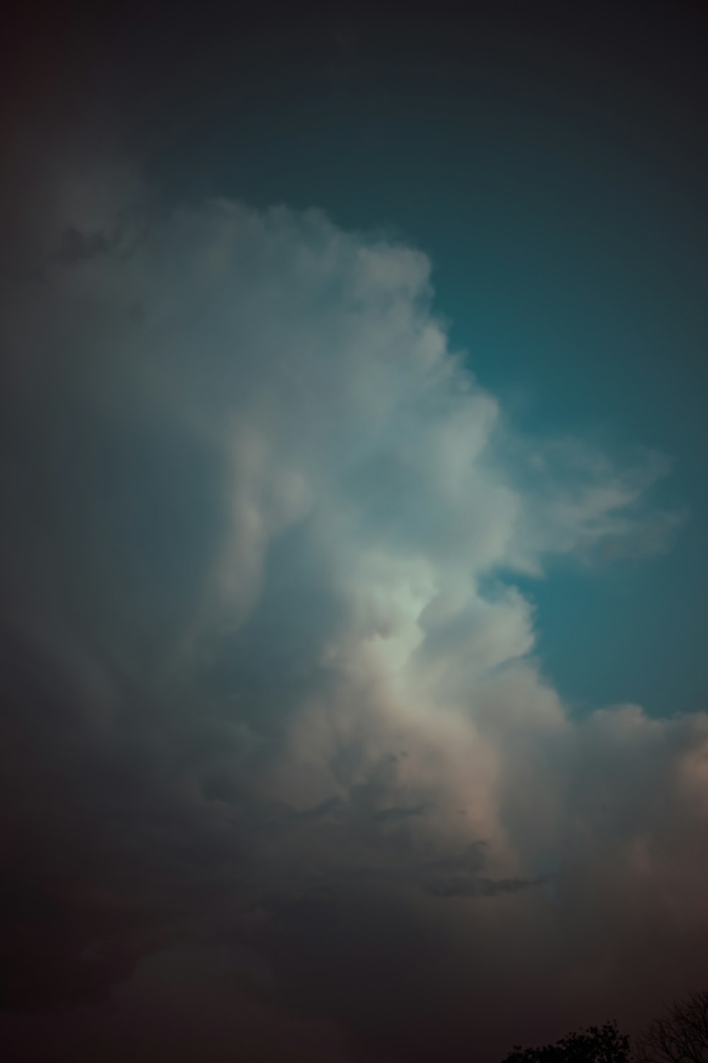 a plane flying through a cloudy blue sky