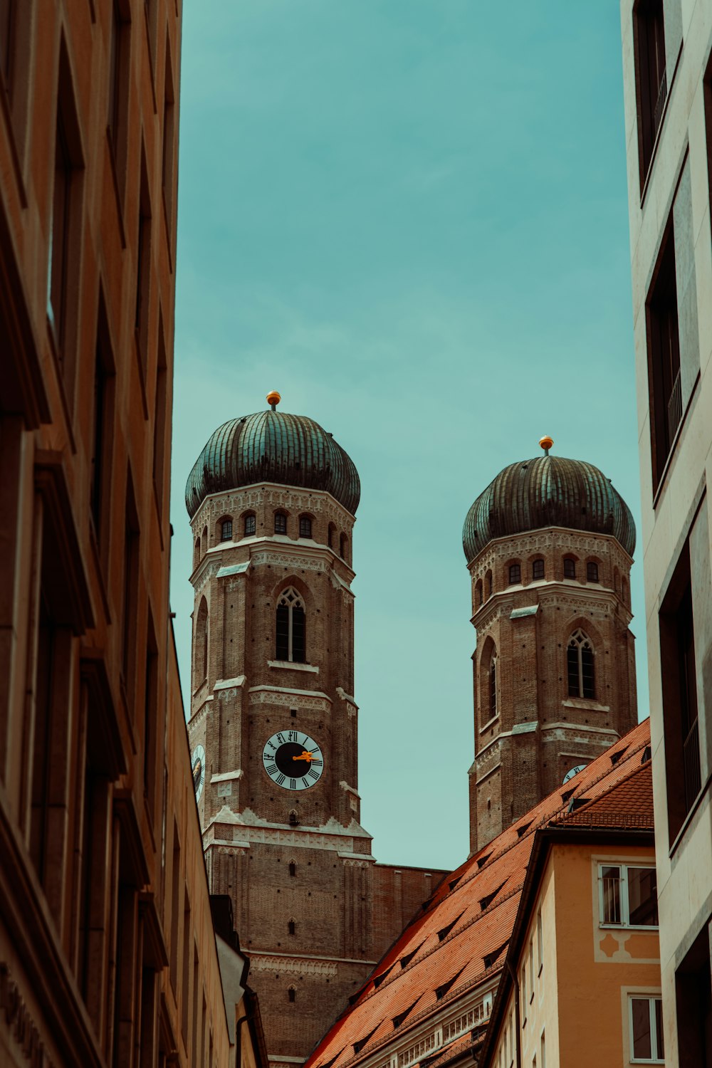 a couple of tall buildings with a clock on each of them