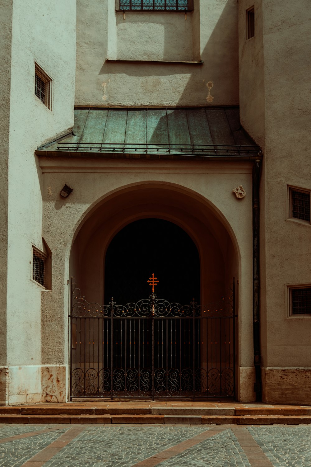 a building with a gate and a cross on it