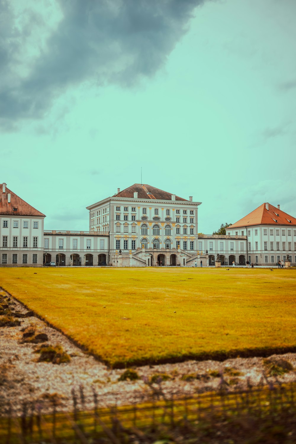 a large white building sitting on top of a lush green field