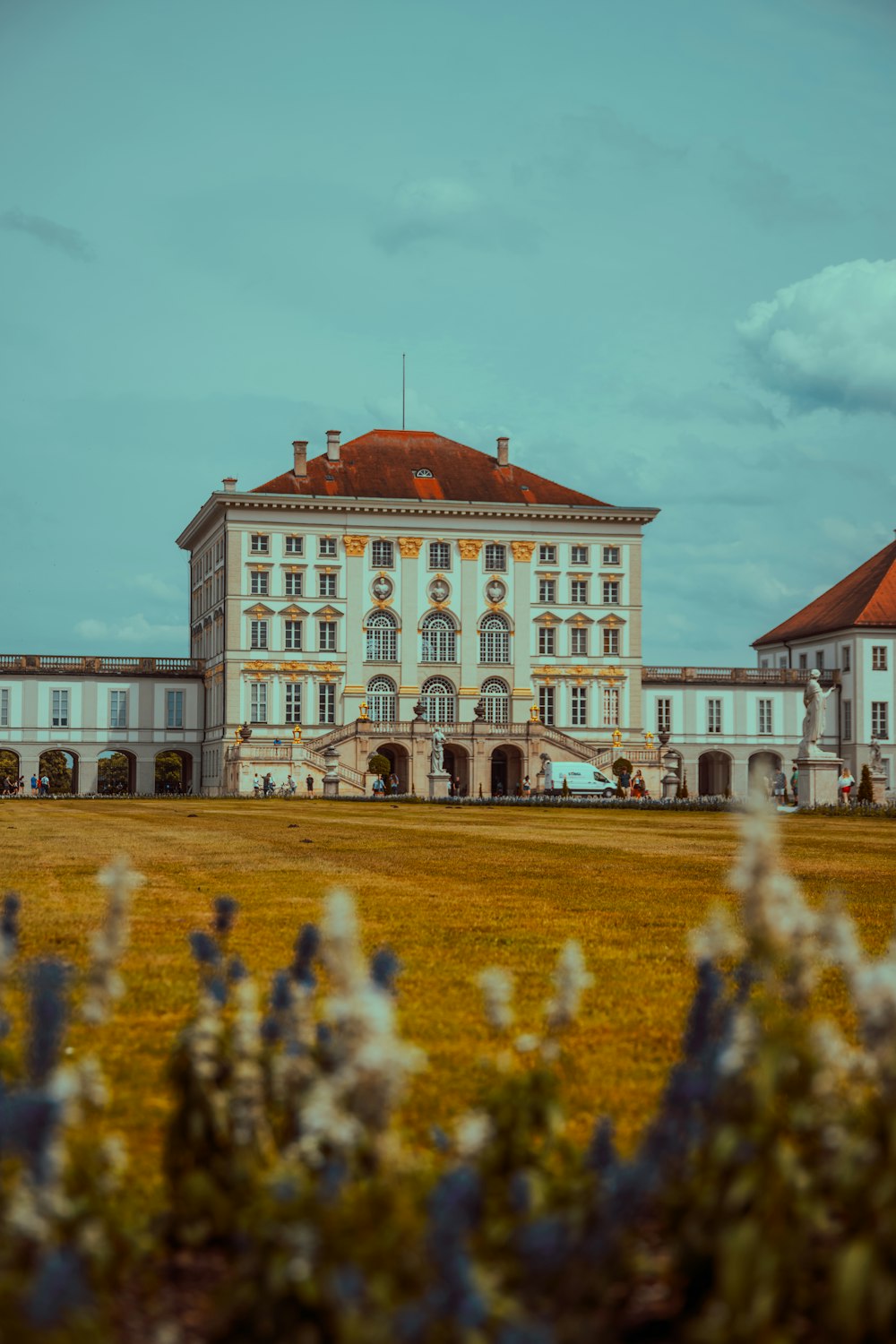 a large white building sitting on top of a lush green field