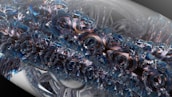An intricate and abstract digital art piece featuring swirling, crystalline structures with a metallic sheen. The design is complex, resembling a fusion of mechanical and organic elements that create a sense of depth and movement.