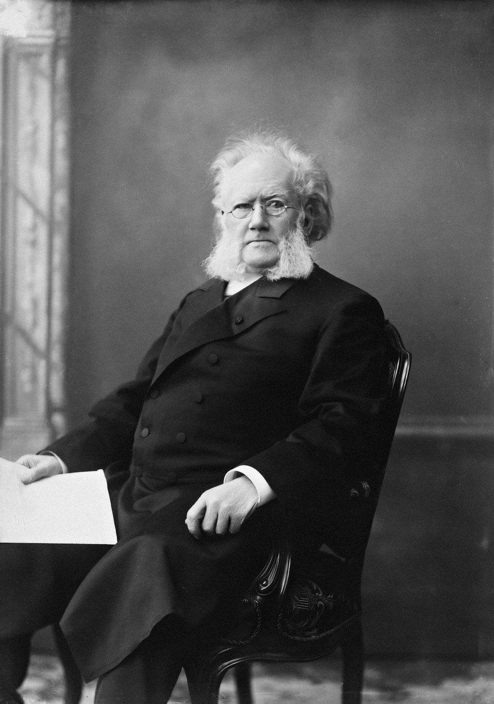 a black and white photo of a man sitting in a chair