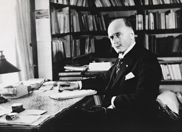 Portrait of Ghayas Uddin Hashmi in his office surrounded by law books.