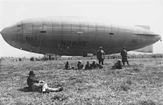 a group of people sitting on the ground in front of an airplane