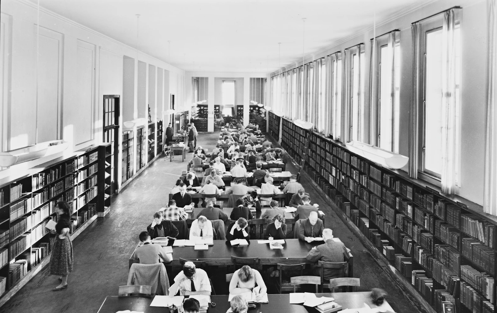 Historic reading hall at Deichmanske Library in Oslo with people seated at tables