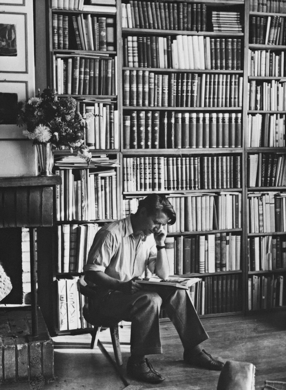a man sitting in a chair in front of a bookshelf