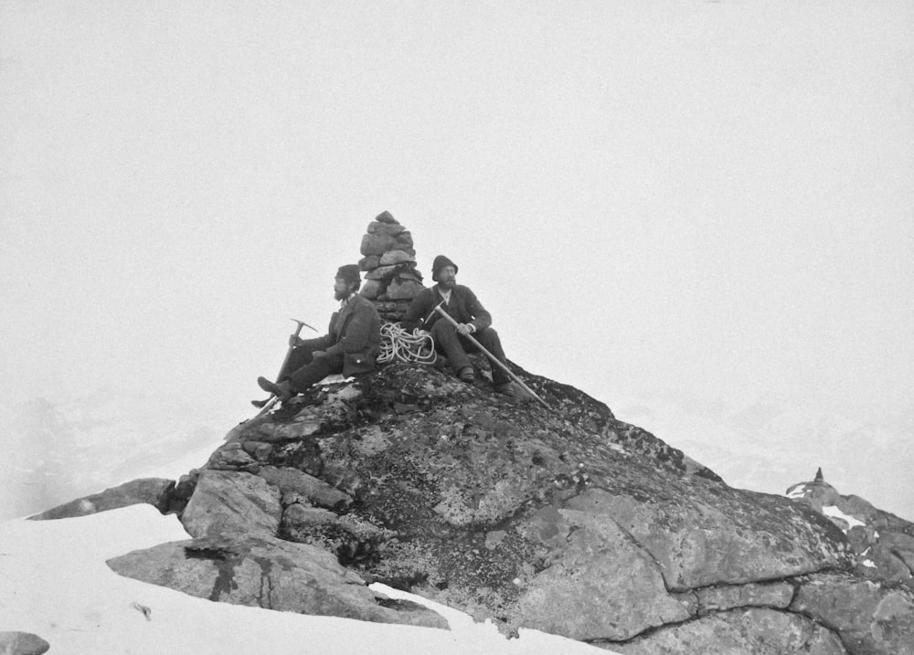 a group of people sitting on top of a snow covered mountain