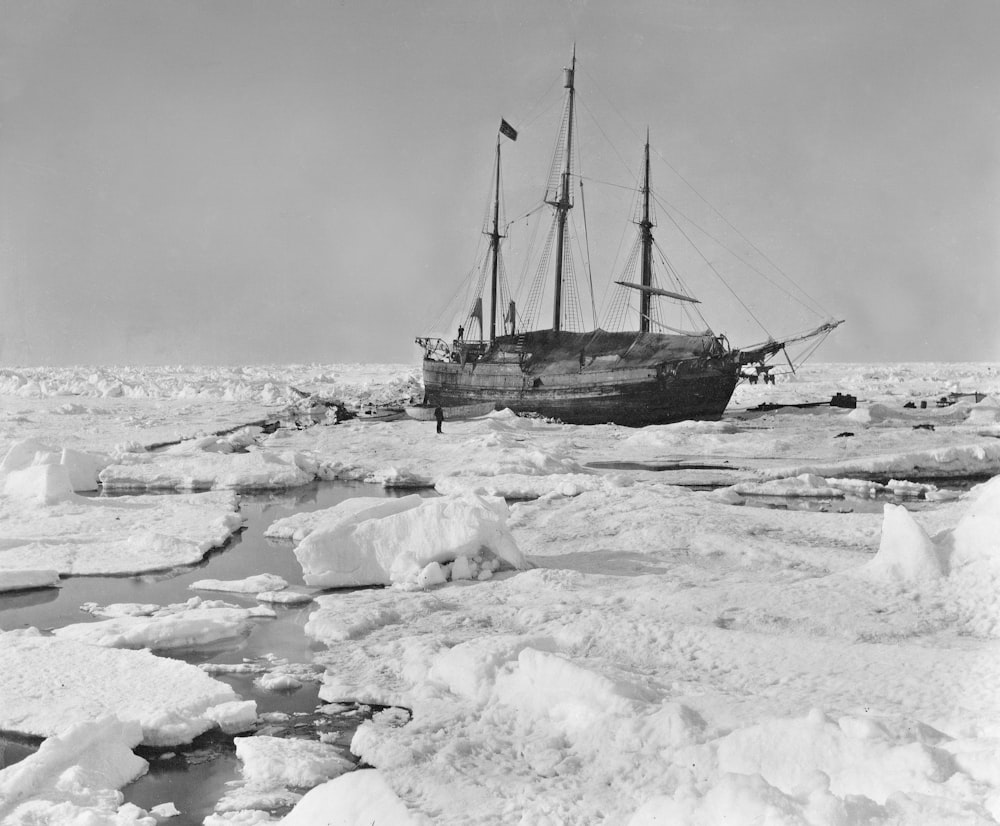 an old ship in the middle of the ocean surrounded by ice