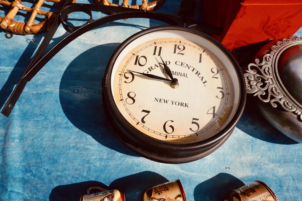 Un reloj sentado encima de una mesa azul