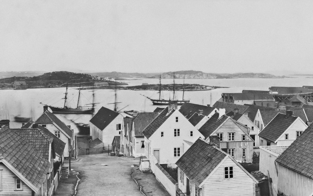 a black and white photo of a town with a harbor in the background