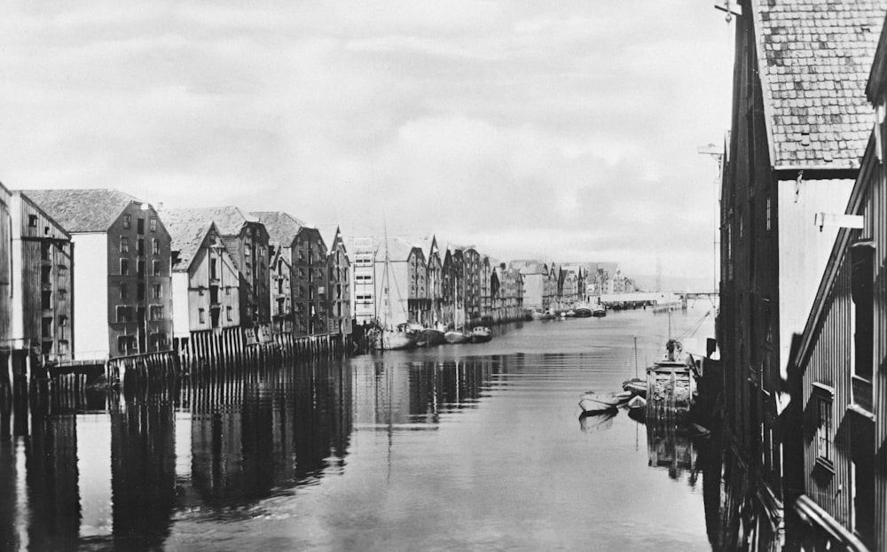 a black and white photo of a river with buildings