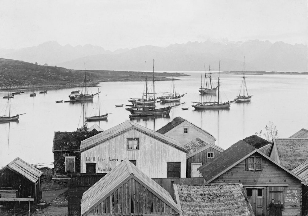 a black and white photo of a harbor filled with boats