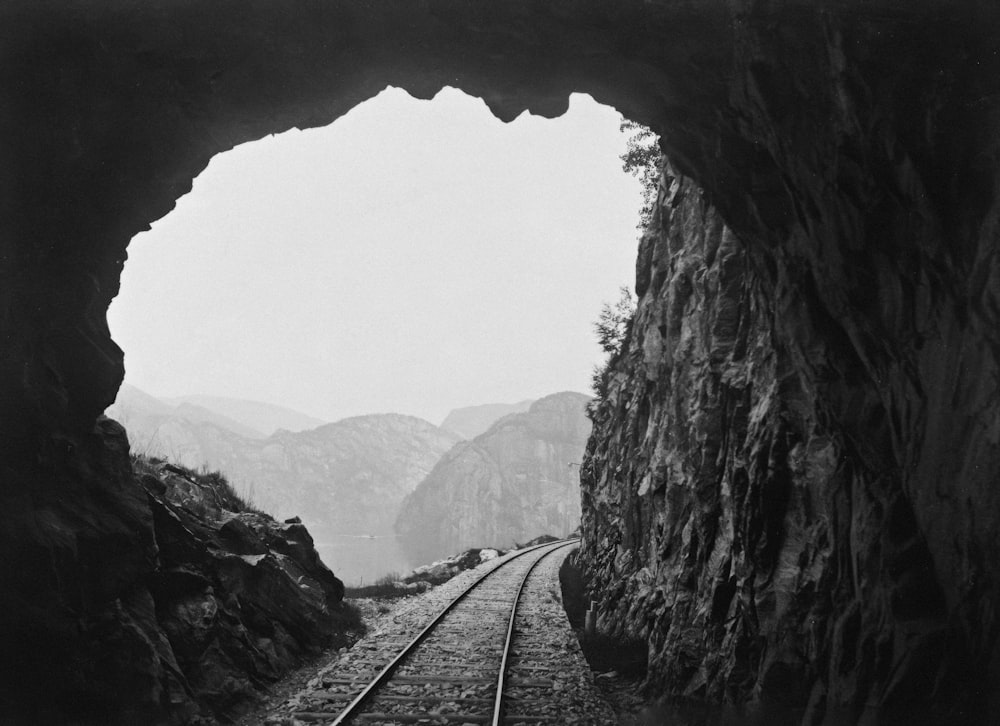 a black and white photo of a train going through a tunnel