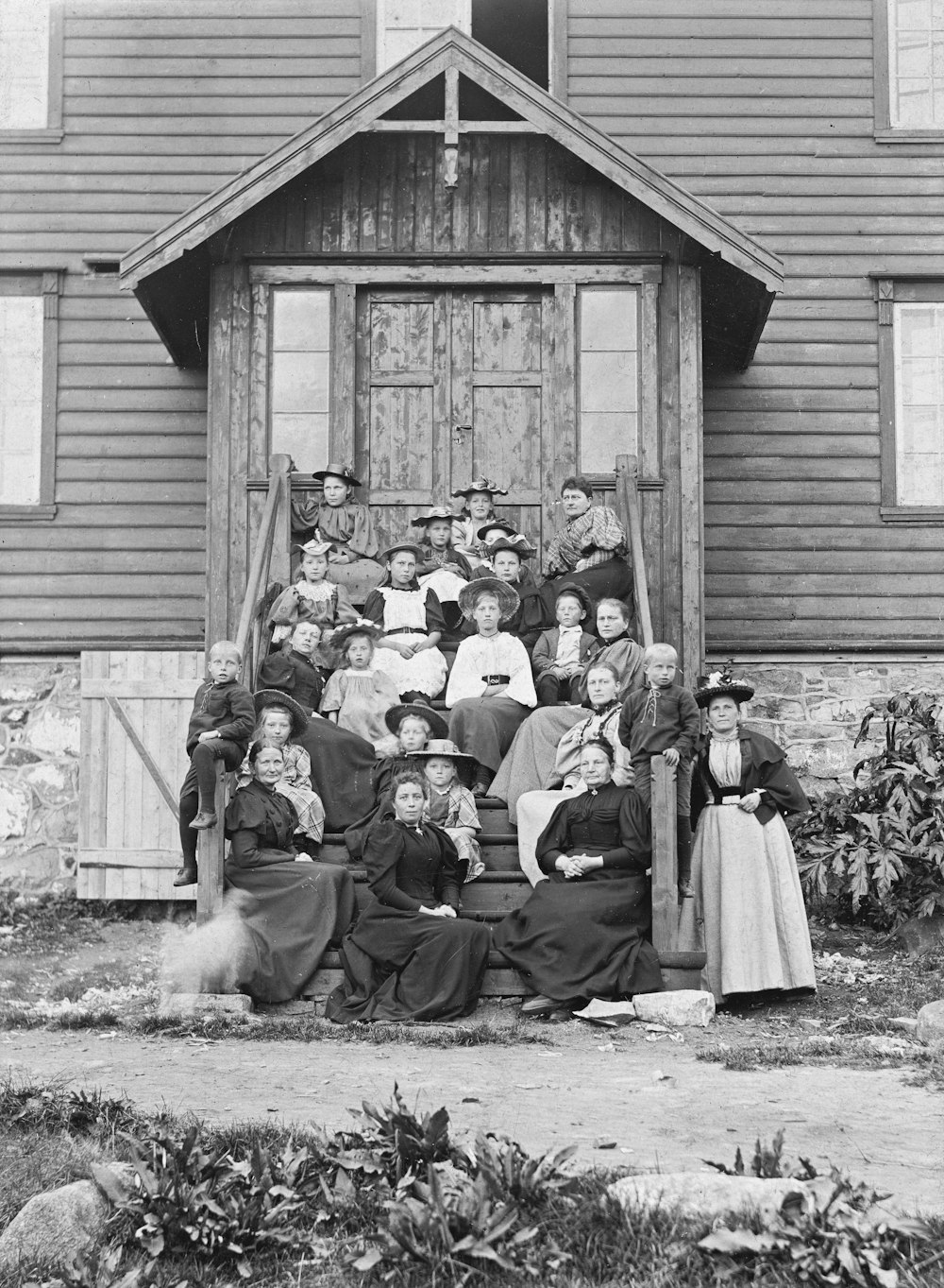 a group of people sitting on the steps of a house