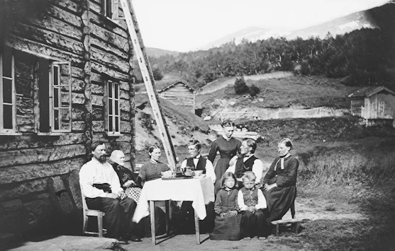A warm family gathering around a rustic wooden table during a countryside trip in old Europe.
